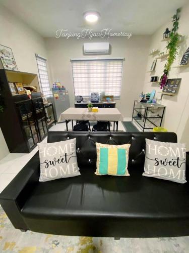 a black couch with pillows in a living room at Tanjung Hijau Homestay - FREE wifi - 2ndFloor - 4 bedrooms in Rawang