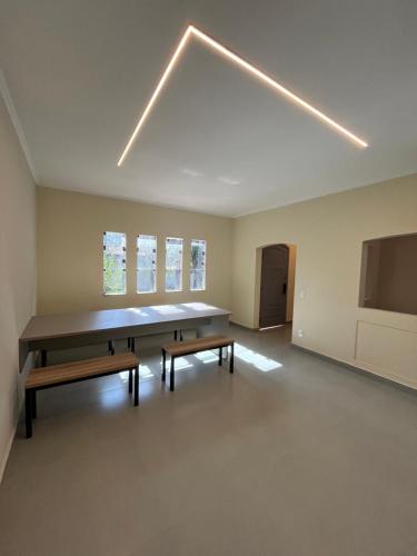 ein leeres Zimmer mit einem großen Tisch und Bänken in der Unterkunft Astor Hostel in Campinas