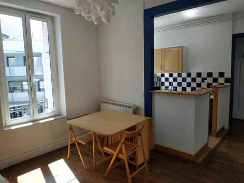 une cuisine avec une table et des chaises dans une pièce dans l'établissement Beau F3 proche tous commerces, à Nancy