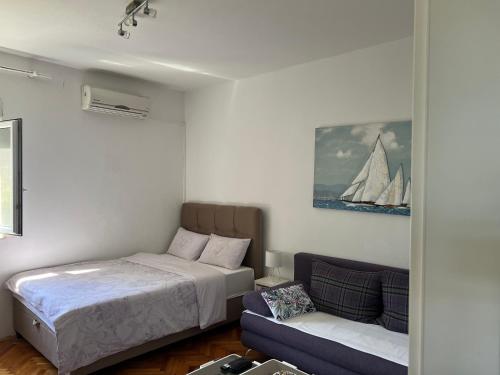 um quarto com uma cama e um sofá em Apartments Mia em Bibinje