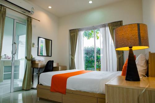 1 dormitorio con cama, escritorio y ventana en Uou Hotel, en Kabin Buri