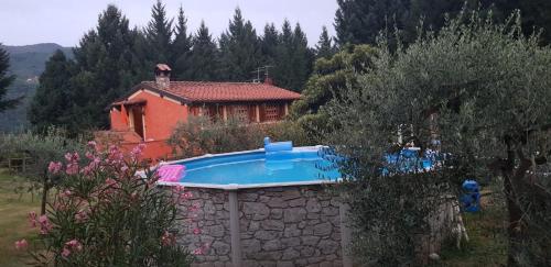 a house with a swimming pool in front of a house at Tenuta Cerbaiola with Pool, Garden & Parking in Borgo a Mozzano