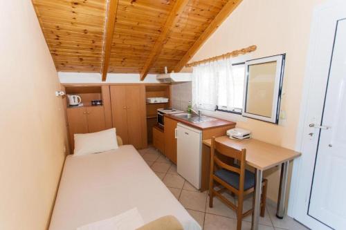 een kleine kamer met een bed en een kleine tafel bij Villa Rozou in Paralia Vrachou