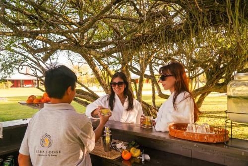 un grupo de tres personas sentadas en una mesa en Ibera Lodge en Mercedes