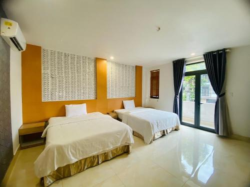 - une chambre avec 2 lits et une grande fenêtre dans l'établissement Sunny 1 Hometel Vinh Long, à Vĩnh Long
