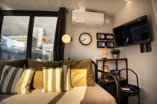 a bedroom with a bed with a clock and a window at The Homeboat Company Sant'Elmo-Cagliari in Cagliari