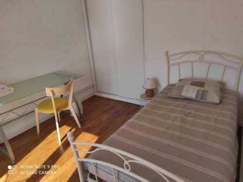 une petite chambre avec un lit et un bureau dans l'établissement Superbe F3 dans résidence calme,, à Nancy