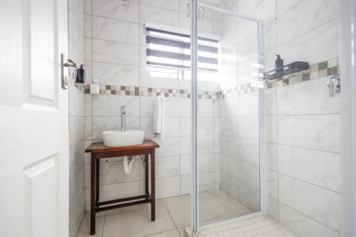 a bathroom with a sink and a glass shower at Safi Smart Self-catering Suite 1 in East London