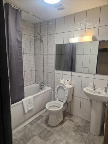 a bathroom with a toilet and a tub and a sink at Himley Country Hotel in Dudley