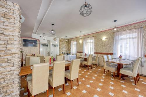 a dining room with tables and chairs and a stone wall at Rooms Centar in Delnice