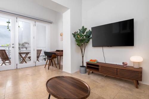 a living room with a flat screen tv on a wall at 2-BR Apt centrally located in OSJ! in San Juan