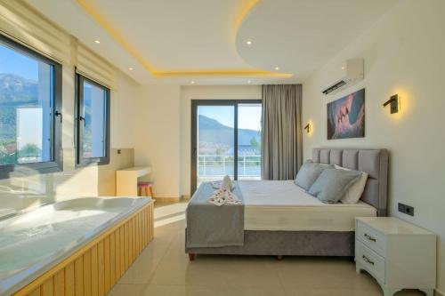 a bedroom with a tub and a bed and a bath room at Alternatif Villaları in Fethiye