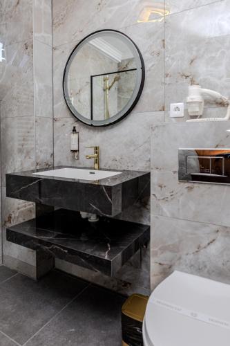 a bathroom with a sink and a mirror on the wall at La Maison de Caroline in Alba Iulia