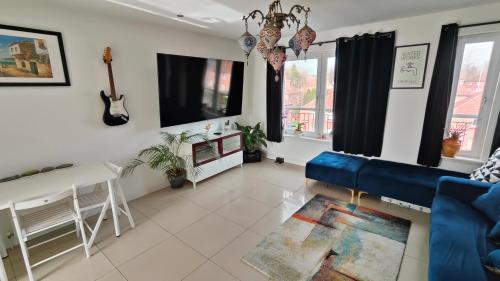 a living room with a blue couch and a table at La Casita, Your Home Away from Home - Free Parking in Glasgow