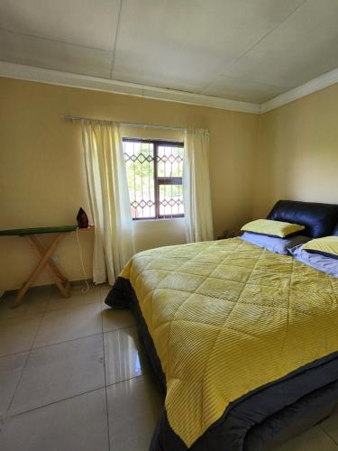 sypialnia z dużym łóżkiem i oknem w obiekcie Dollar Zone w mieście Manzini