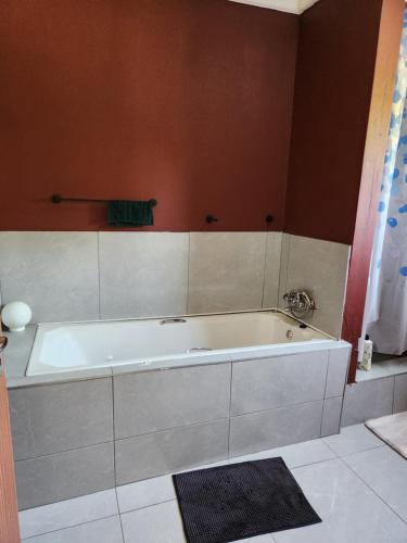 ein Bad mit einer großen Badewanne in einem Zimmer in der Unterkunft Dollar Zone in Manzini