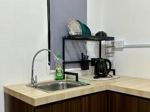 eine Küchentheke mit einer Spüle und einer Mikrowelle in der Unterkunft Dreamy Cozy Studio Meritus Residensi Perai in Perai