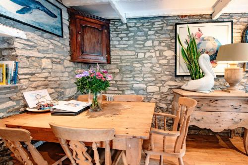 a dining room with a wooden table and chairs at Cosy Little Hyde Cottage, Swanage in Swanage