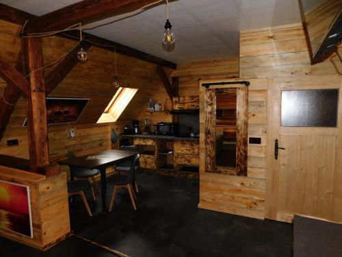a dining room and kitchen in a log cabin at Haus Feierabend in Plodda