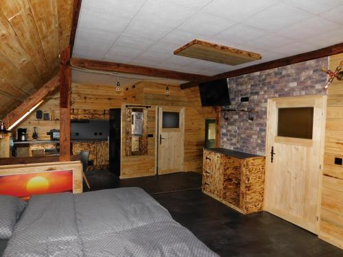 1 dormitorio con 1 cama en una habitación con paredes de madera en Haus Feierabend, en Plodda