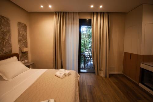 a bedroom with a bed and a sliding glass door at Vila Koja Boutique Hotel in Tirana
