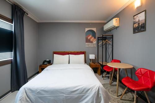 um quarto com uma cama, uma mesa e cadeiras em Gung Business Hotel em Jeonju
