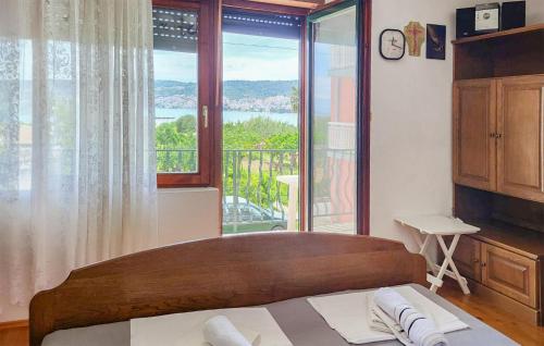 1 dormitorio con cama y ventana grande en 3 Bedroom Amazing Apartment In Trogir en Trogir