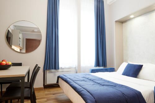 a bedroom with a bed and a table and a mirror at Milan Retreats in Milan