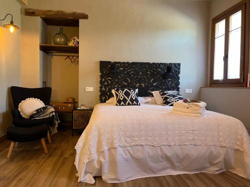 a bedroom with a large bed and a chair at Belaustegi turismo rural in Ispáster