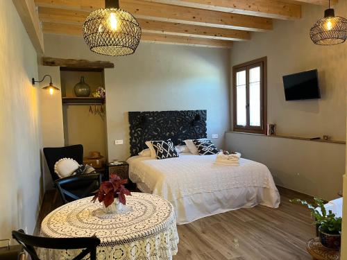 a bedroom with two beds and a table and two chairs at Belaustegi turismo rural in Ispáster