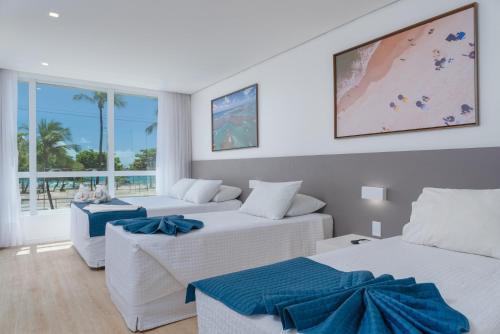 un soggiorno con 2 letti e un divano di Hotel Praia Bonita Jangadeiros Pajuçara a Maceió