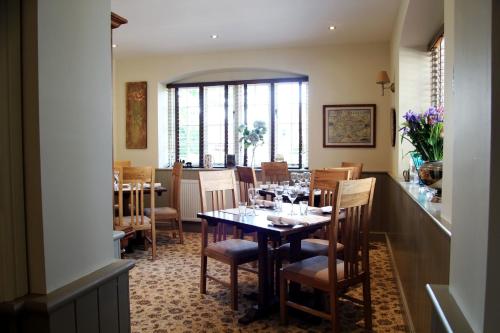 a dining room with a table with wine glasses on it at The Six Bells in Bourne