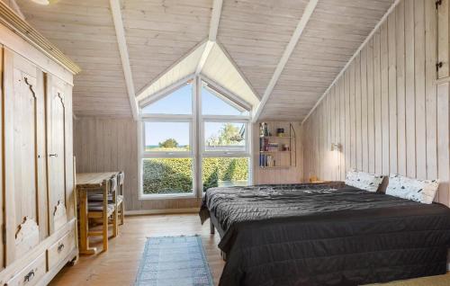 een slaapkamer met een bed, een raam en een bureau bij 3 Bedroom Amazing Home In Tranekr in Lokkeby
