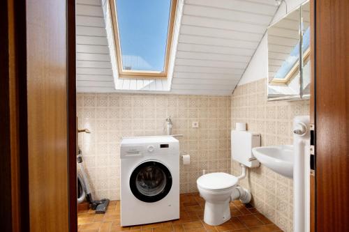 a bathroom with a washing machine with a dog in it at Ferienwohnung Lange in Waldstetten