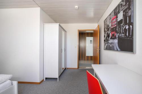 a room with a white table and red chairs at Ferienwohnung Lange in Waldstetten