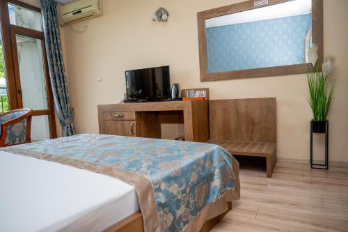 a bedroom with a bed and a table and a mirror at Lucky Hotel in Veliko Tŭrnovo