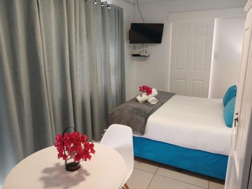 a bedroom with a bed and a table with flowers on it at Saldanha Bay Lodge in Saldanha
