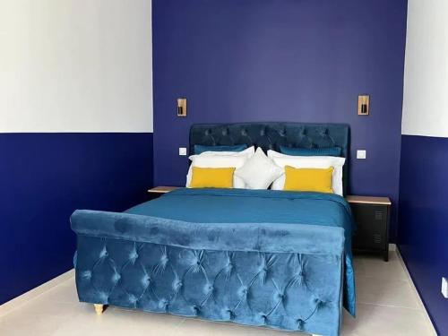 a bedroom with a blue bed with yellow pillows at Villa charmante à Châteaurenard avec piscine privée in Châteaurenard