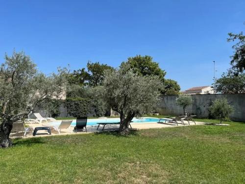 une cour avec une piscine bordée de chaises et d'arbres dans l'établissement Villa charmante à Châteaurenard avec piscine privée, à Châteaurenard