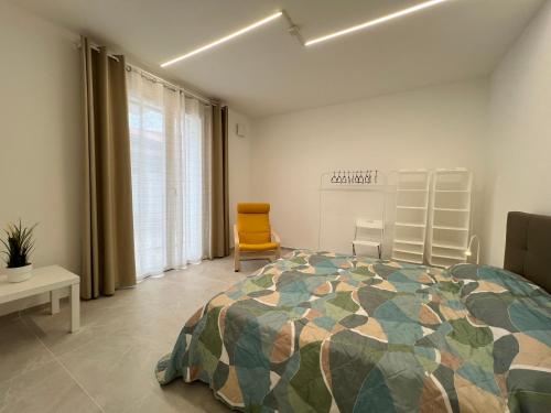 1 dormitorio con 1 cama y 1 silla amarilla en Casa Vacanza Trecastelli Senigallia (AN), en Trecastelli
