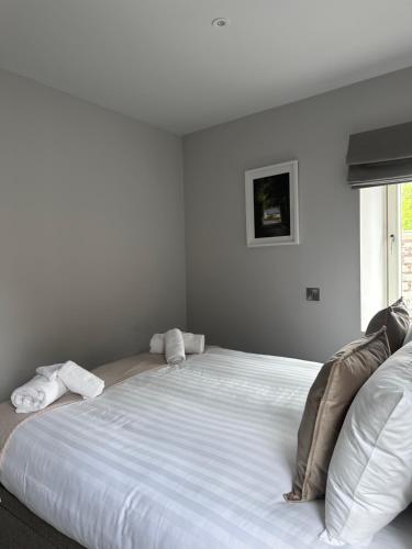 a large white bed in a room with a window at Number One Townhouse in Kinsale