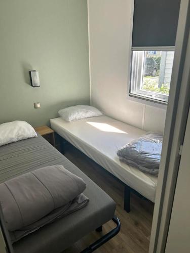 une petite chambre avec deux lits et une fenêtre dans l'établissement Bungalow cosy à Vendres avec piscine partagée, à Vendres