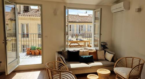 - un salon avec un canapé et une grande fenêtre dans l'établissement Terrasse - Hyper centre - 2 chambres - Parking gratuit - Calme & lumineux - Arrivée autonome, à Marseille