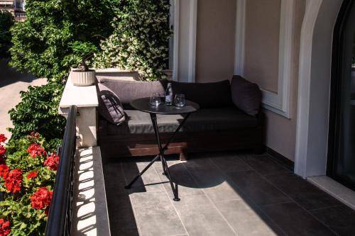 a black couch sitting on a balcony with a table at Vila Koja Boutique Hotel in Tirana