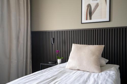 a bed with a white pillow on it in a room at VICI Hotels Linköping in Linköping