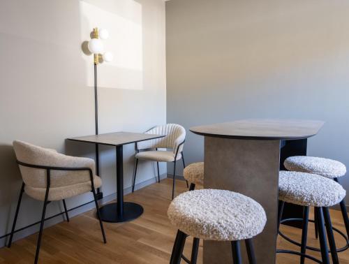 a bar with stools and a table in a room at VICI Hotels Linköping in Linköping