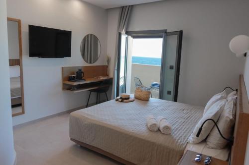 a bedroom with a bed with a television and a desk at Tropical Beach A in Amoudara Herakliou
