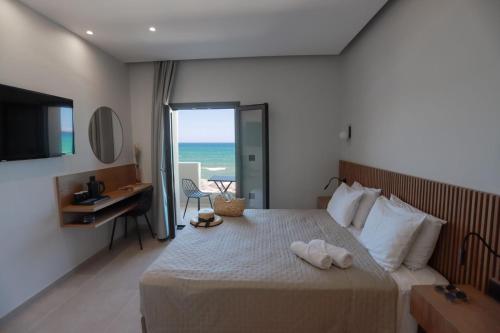 1 dormitorio con 1 cama y vistas al océano en Tropical Beach A, en Amoudara Herakliou