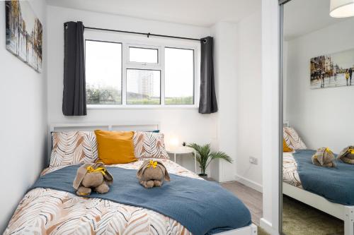 two stuffed animals sitting on a bed in a bedroom at Large 3 Bed House - Free Parking- by Holiday Homes in Lincolnshire
