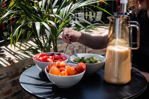 a table with two bowls of fruit and a drink at Vila Koja Boutique Hotel in Tirana